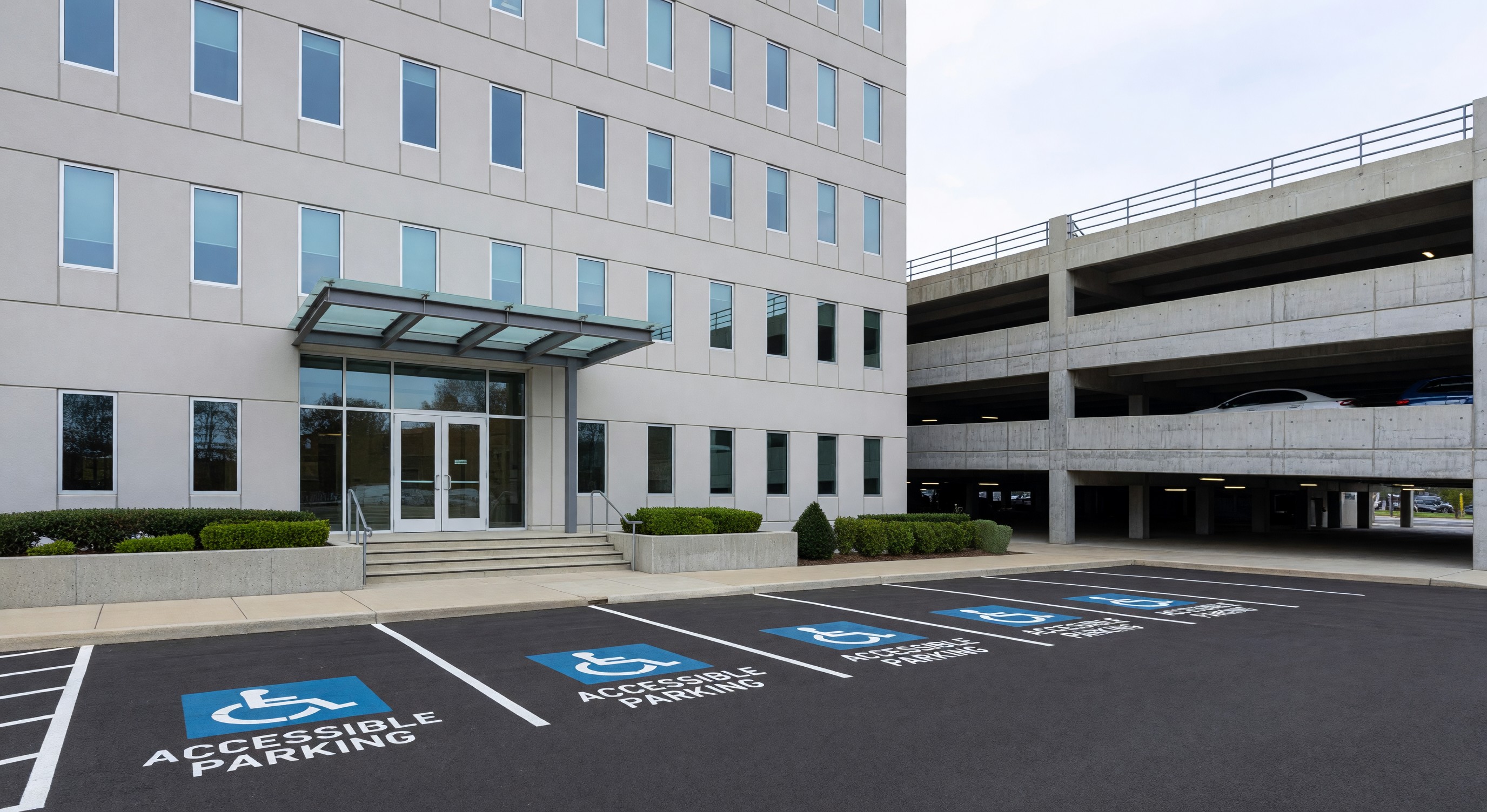 Government office building with structured parking facility and accessible parking spaces near main entrance