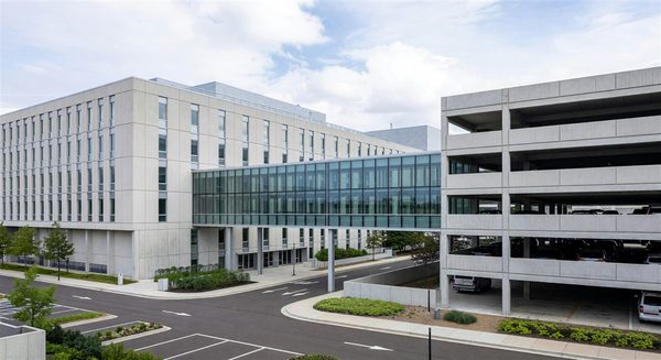 Hospital building with multi-level parking structure connected by walkway