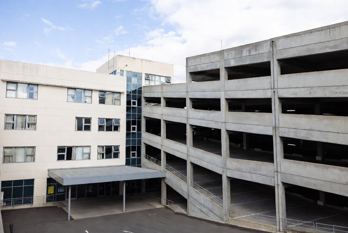 Hospital building with multi-level parking structure connected by walkway