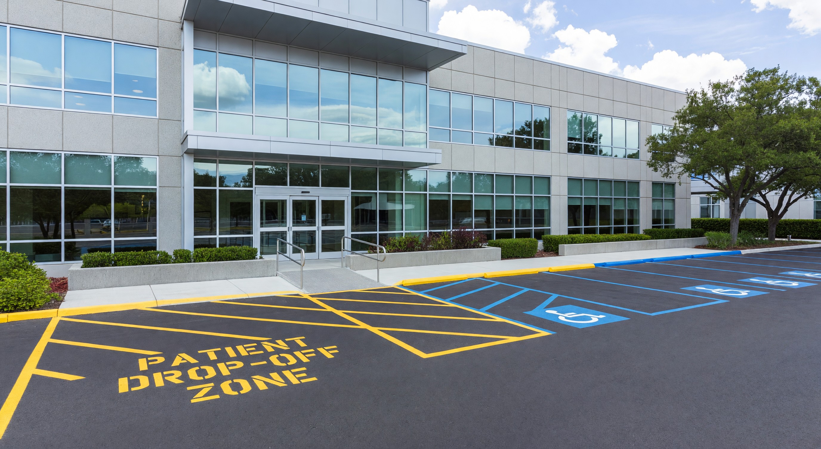 Medical office building entrance with accessible parking spaces and patient drop-off zone near front entrance