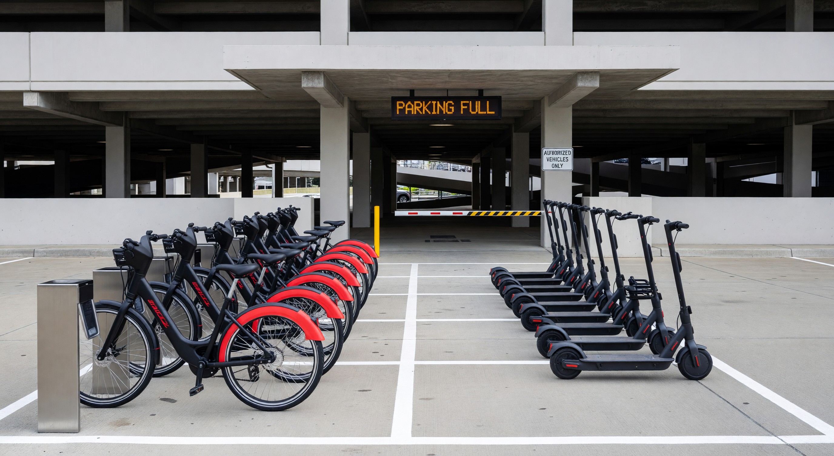 Parking facility entrance with dedicated bikeshare docking station and scooter parking area for first/last mile connections