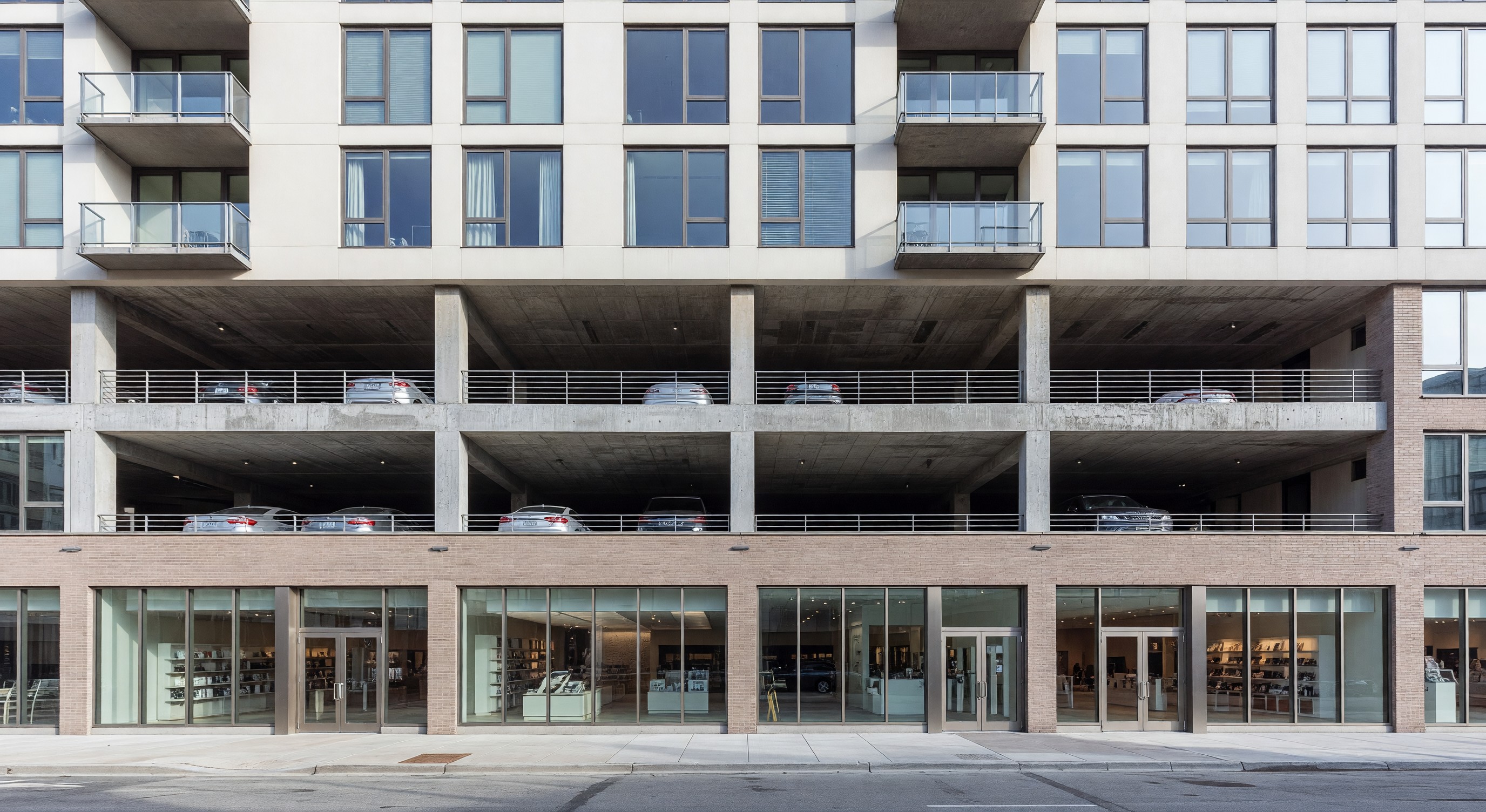 Mixed-use building with ground-floor retail, parking levels above, and residential units at top