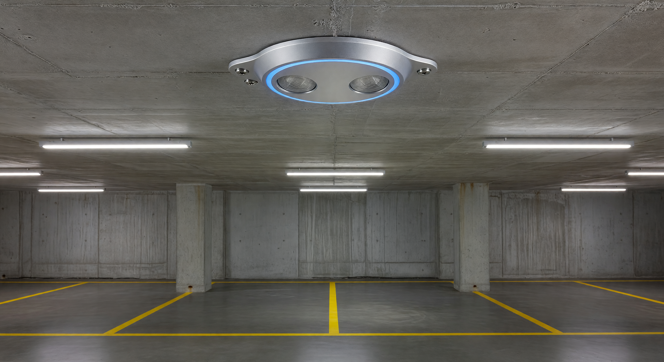 Close-up of ultrasonic parking occupancy sensor mounted on a garage ceiling above an empty parking space