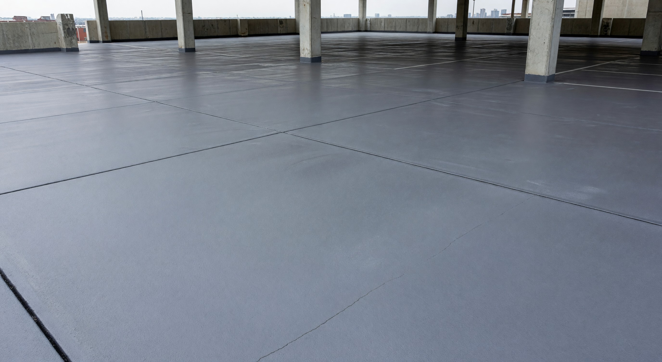 Parking structure deck with waterproofing membrane and traffic coating applied