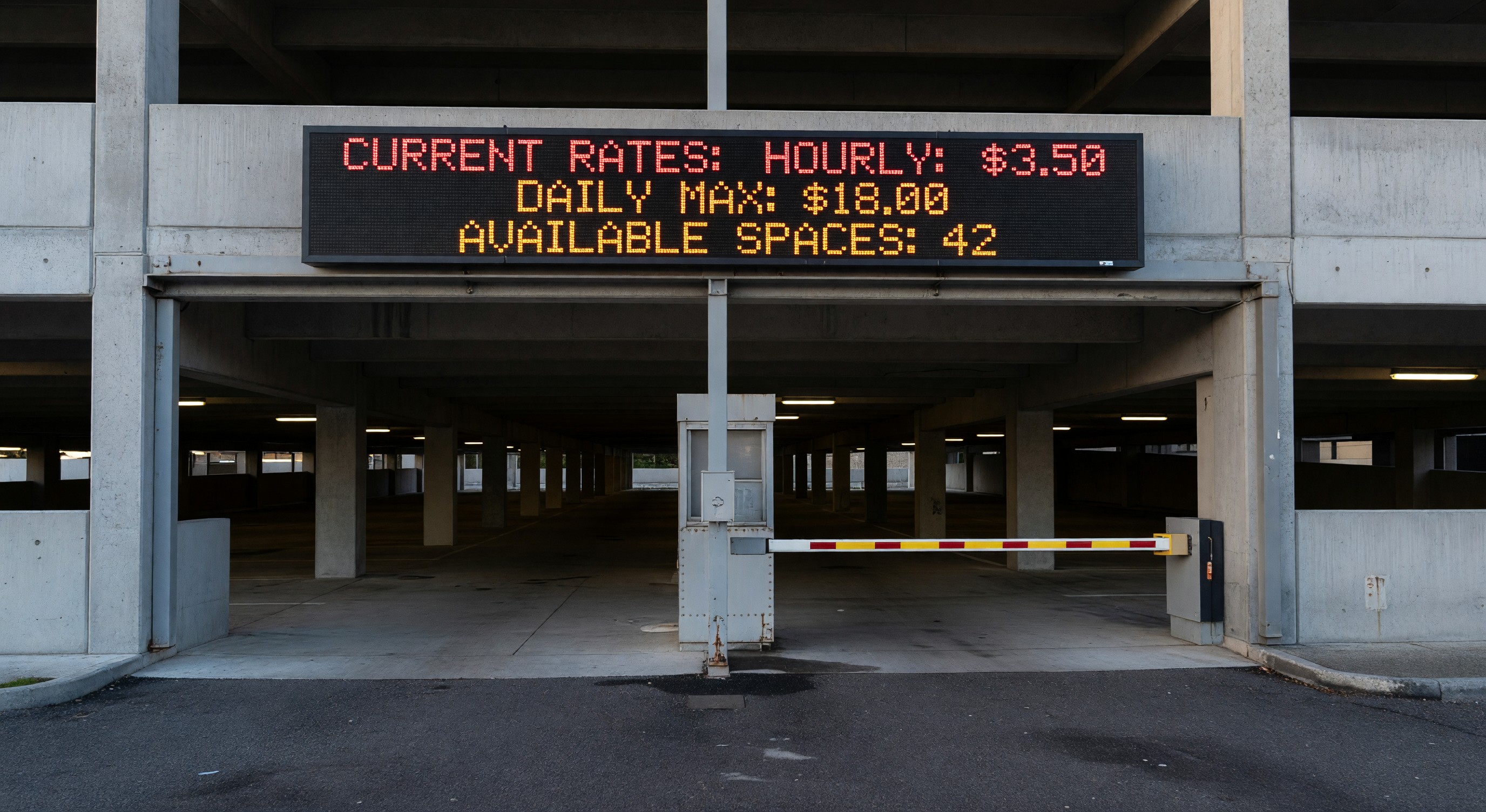 Parking structure entrance with LED digital sign displaying current rates and available space count