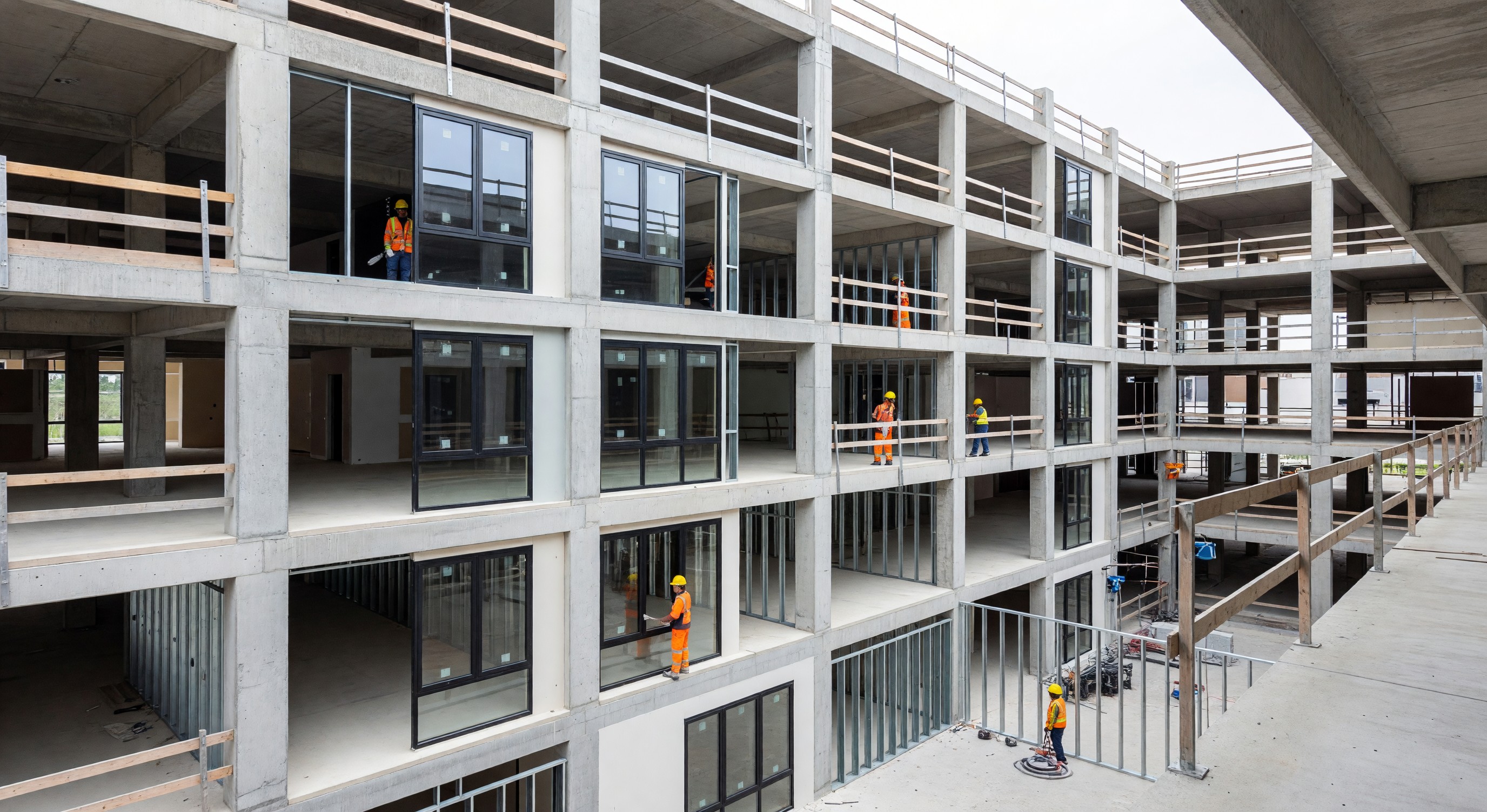 Former parking structure mid-conversion showing new floor plates and windows being installed for residential use
