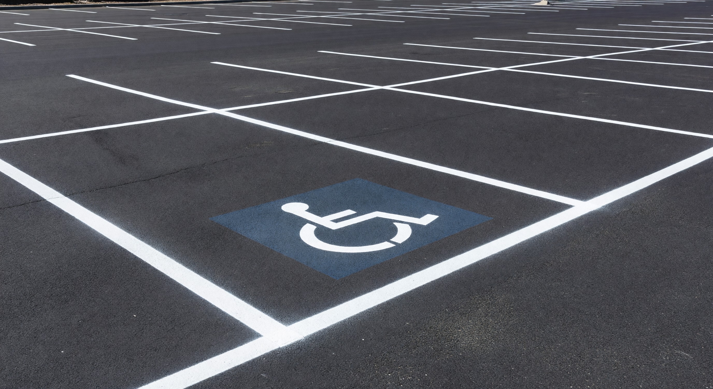 Fresh white parking lot line markings with ADA accessible space markings visible
