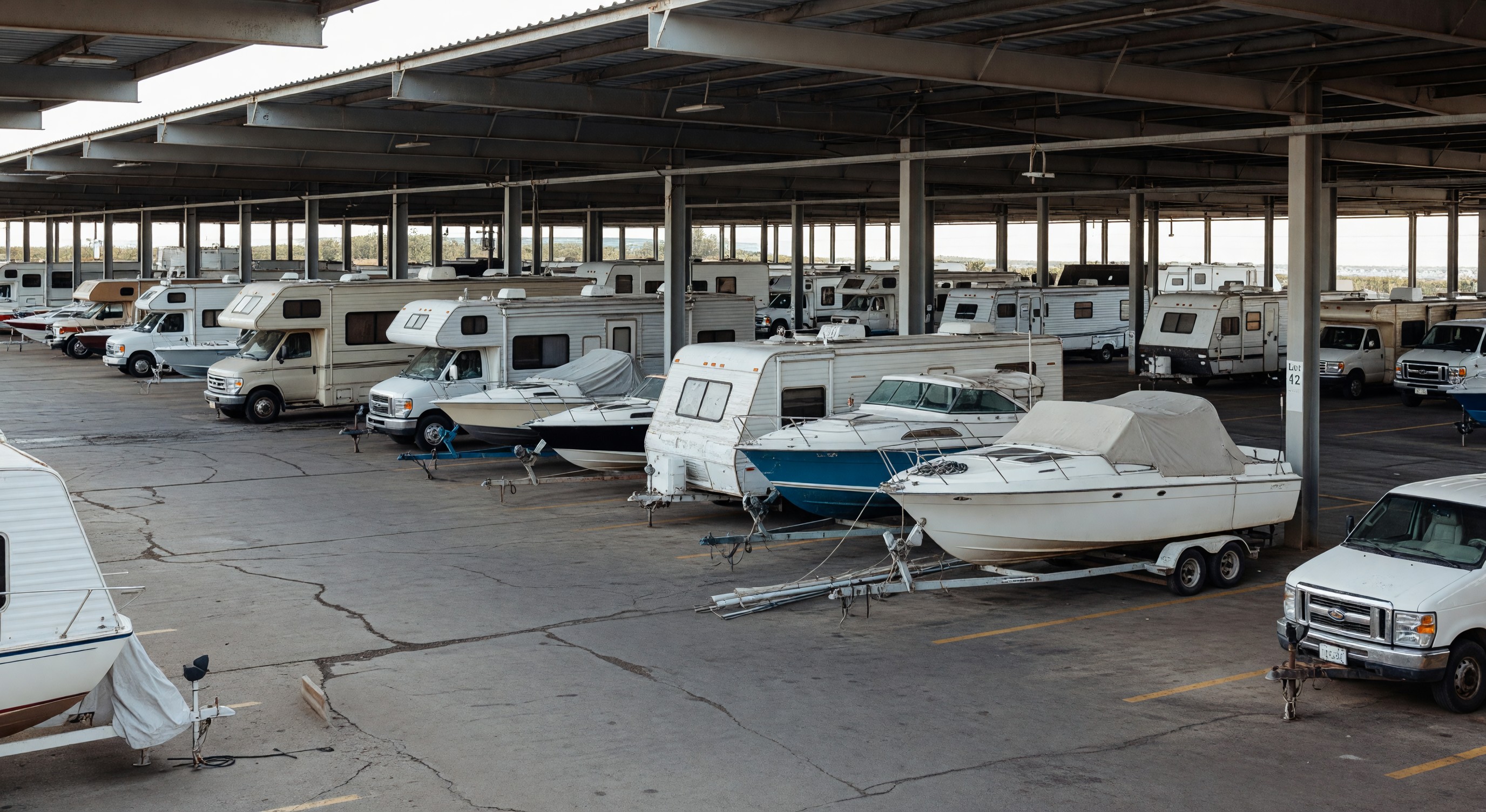 Outdoor parking facility with RVs and boats in long-term covered storage spaces
