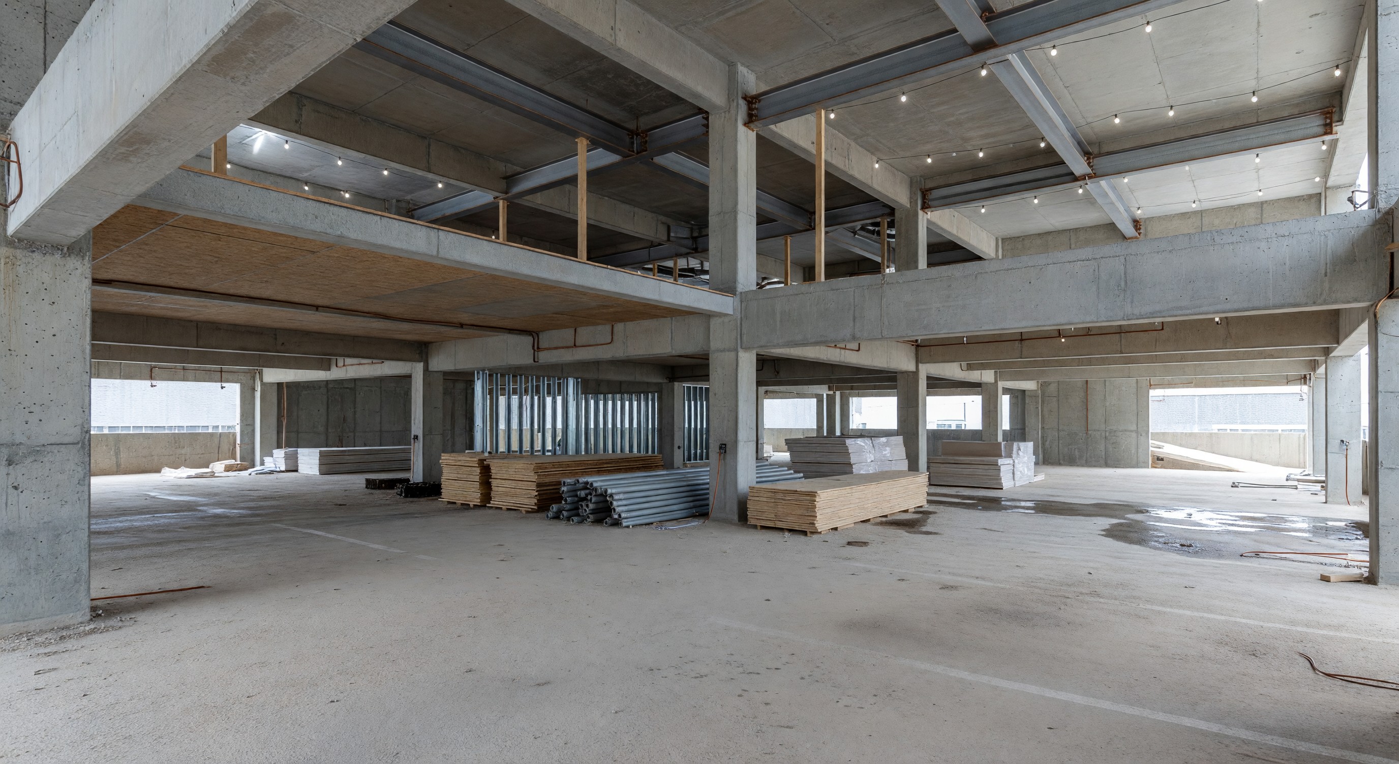 Parking garage under conversion to mixed use residential building showing structural elements and new floors