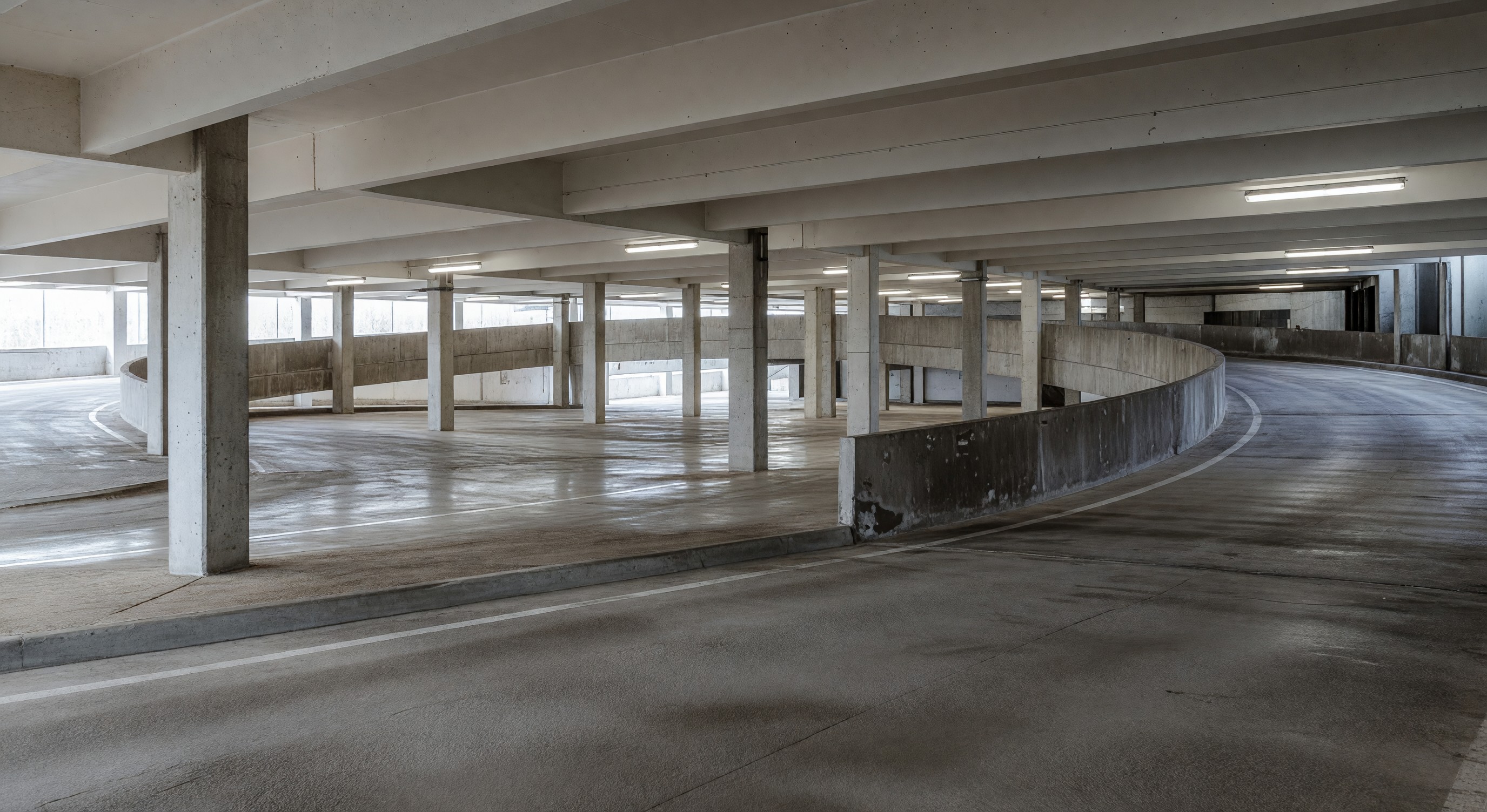 Interior view of a multi-level parking structure showing ramps and column spacing