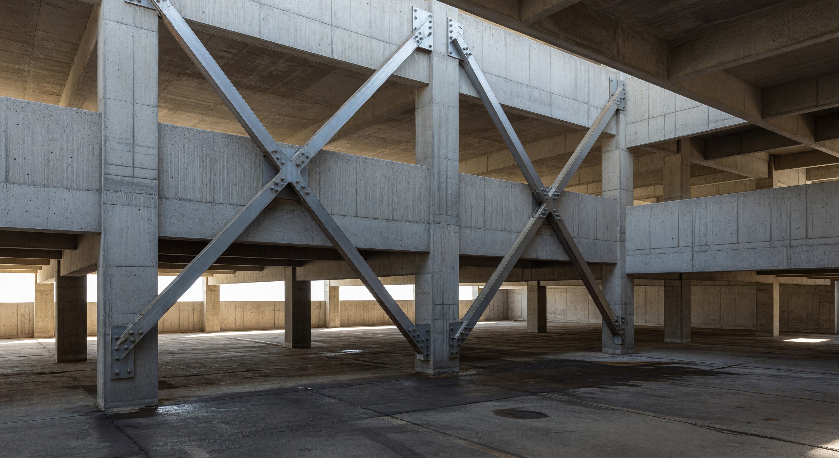 Parking structure with seismic bracing and concrete shear walls visible in the structural frame