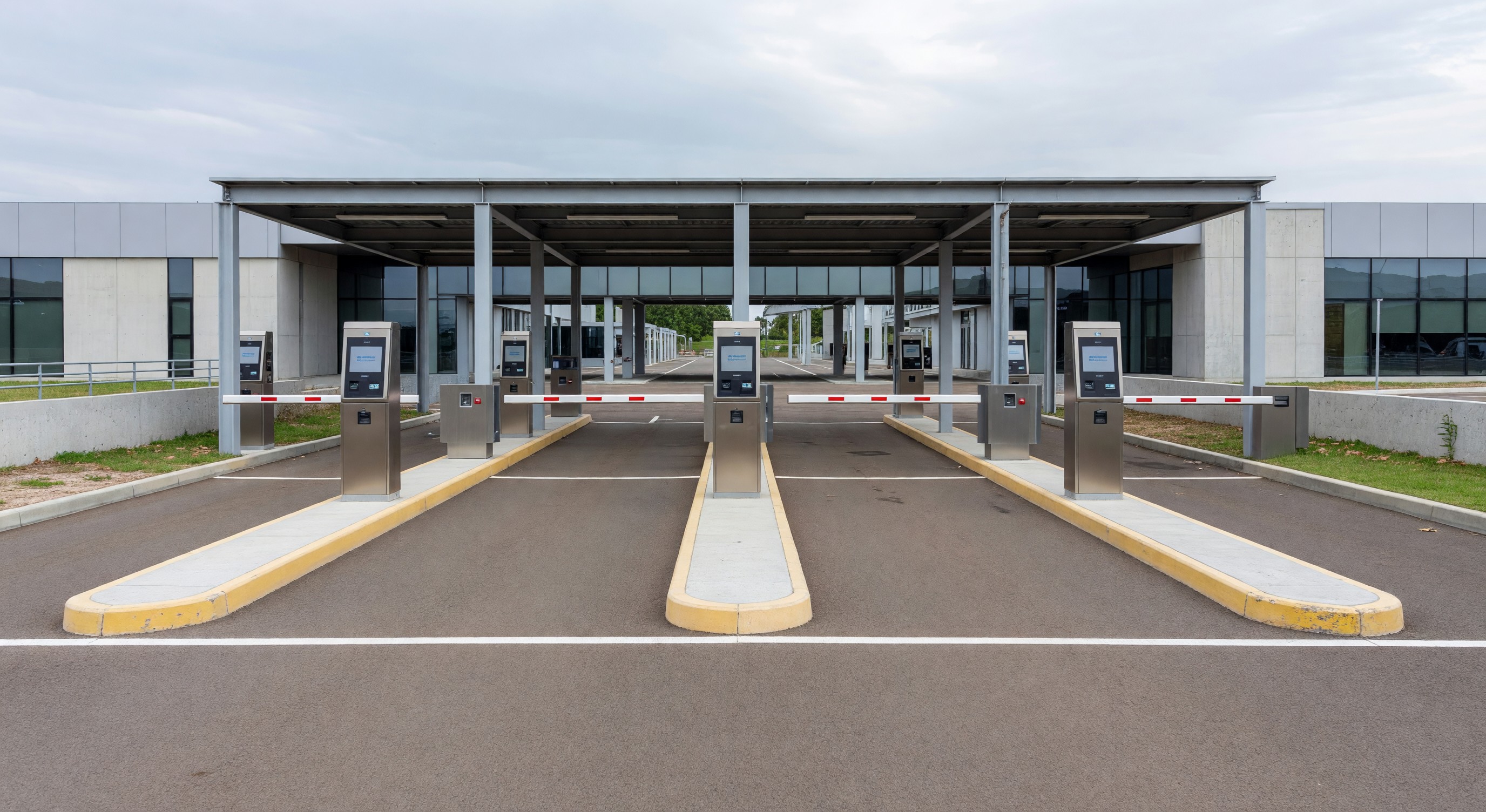 Parking facility entry plaza showing multiple lanes with payment equipment and queuing areas
