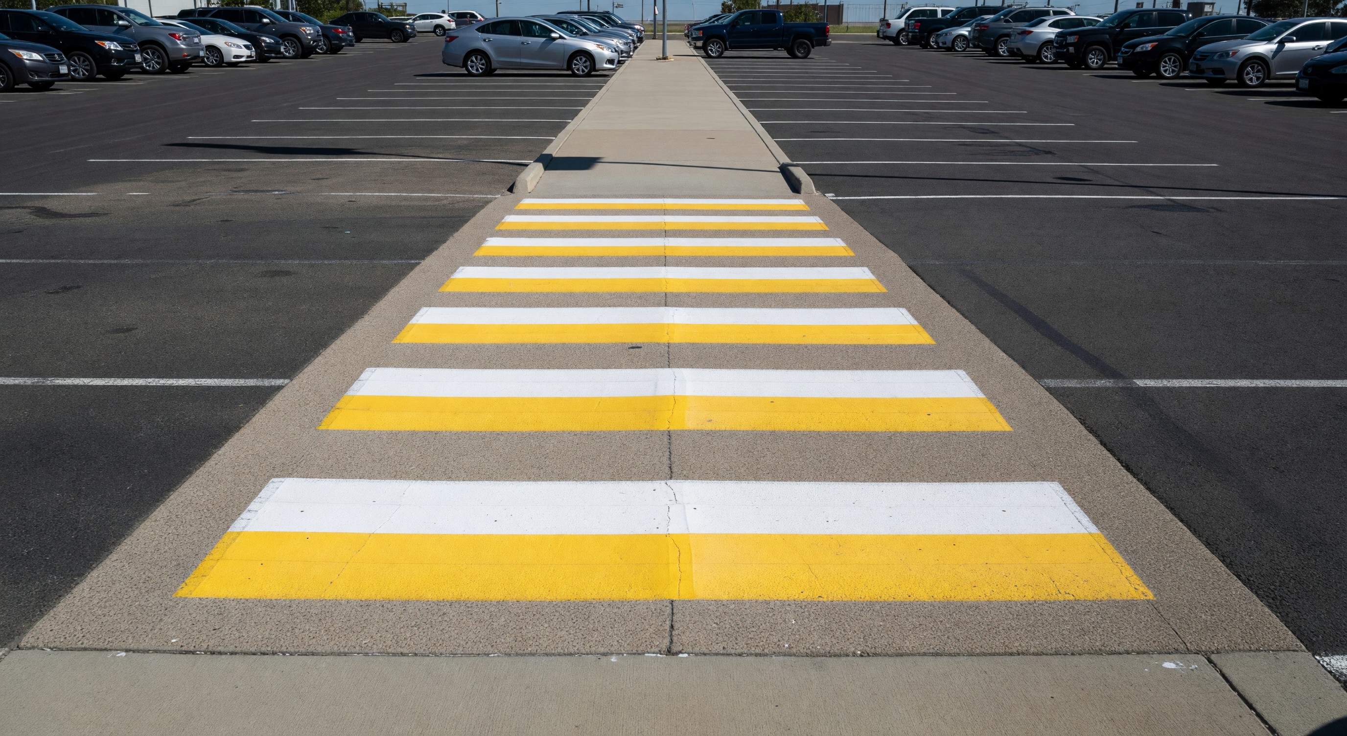 Pedestrian crosswalk in a parking lot with raised crossing and high-visibility markings