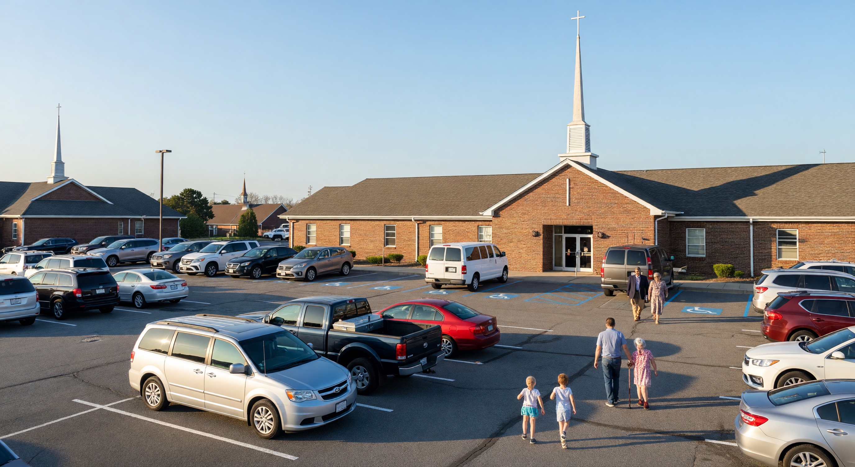 Church parking lot on Sunday morning with congregation vehicles and accessible spaces near main entrance