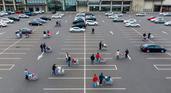 Shopping mall parking lot from above with shoppers walking